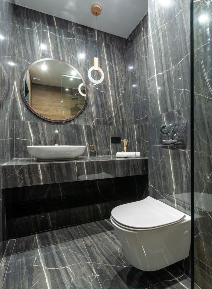 why-choose-us Luxurious bathroom interior featuring sleek marble walls, floating sink, and a contemporary toilet design.